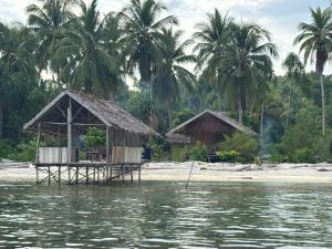 a house on the shore of a body of water at Ina Homestay in Mios Besar
