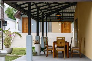 a patio with a table and chairs under a pergola at Centri Villa in Anuradhapura