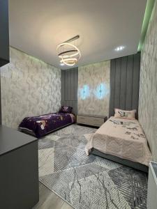 a bedroom with two beds and a chandelier at White Guest House in Samarkand