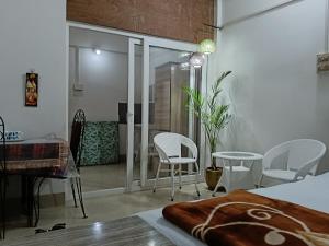 a bedroom with white chairs and a table and a room at Bijoy Villa in Guwahati