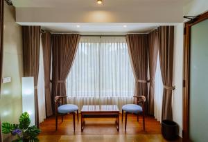 a room with two chairs and a table and a window at Centri Villa in Anuradhapura