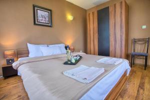 a bedroom with a large white bed with towels on it at Guest House Slunchev Cviat in Tsigov Chark +38 photos