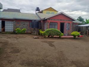 a red building with bushes in front of it at Kruse Compound in Lake View Estate +4 photos