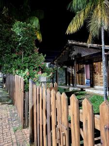 a wooden fence in front of a house at Chalé Pura Vida - Casa de madeira no centro in São Roque de Minas +8 photos