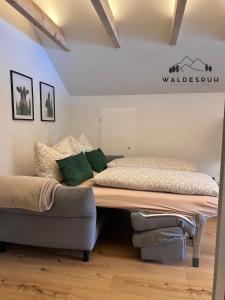 a bed and a couch in a room at Waldesruh in Grünenbach