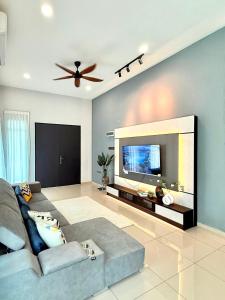 a living room with a couch and a flat screen tv at Jinta House Cherating in Kampong Baharu