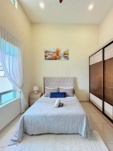 a bedroom with a large bed and a window at Jinta House Cherating in Kampong Baharu