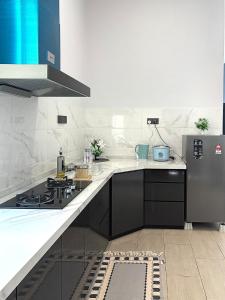 a kitchen with a stove and a refrigerator at Jinta House Cherating in Kampong Baharu +6 photos
