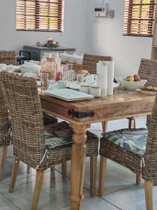 a wooden table with chairs and a laptop on it at Lady D Exclusive Abode in Polokwane