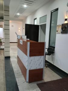 an office cubicle with a desk and a television at Prince Vatika in Alwar