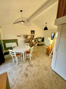 a dining room with a white table and chairs at Grand studio avec terrasse in Saint-Marcel-lès-Valence