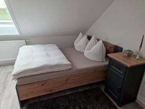 a bed with white pillows on it in a room at Moderne Ferienwohnung in Hainichen in Hainichen