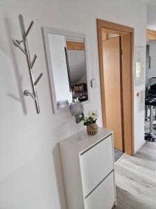 a white dresser in a room with a mirror at Moderne Ferienwohnung in Hainichen in Hainichen
