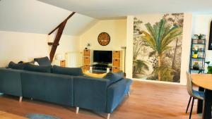 a living room with a blue couch and a table at Gîte L'Orée des Bois in Paimpont