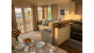a living room with a couch and a table at Sunset Bay Aberaeron in Aberaeron
