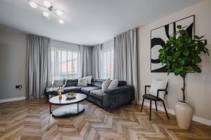 a living room with a couch and a table at JW Canmore ApartHouse in Glasgow +42 photos