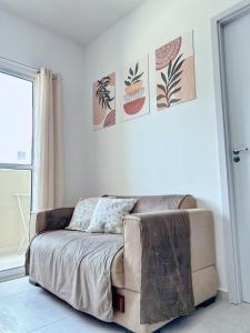a bedroom with a couch and posters on the wall at Apartamento completo com lazer in João Pessoa +16 photos