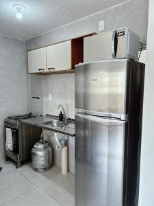 a kitchen with a stainless steel refrigerator with a microwave at Apartamento completo com lazer in João Pessoa