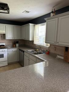 a kitchen with white cabinets and a sink at Country house in Covington