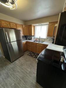 a kitchen with wooden cabinets and a stainless steel refrigerator at Blended Nest in Green Bay