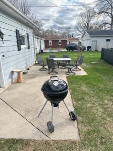 a grill in a backyard with a table and chairs at Blended Nest in Green Bay