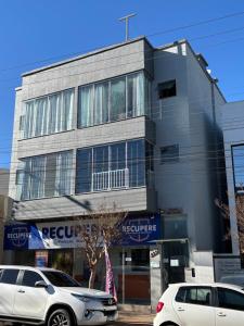 a building with cars parked in front of it at Apartamento no Centro 2 Wi-Fi Garagem in Vacaria