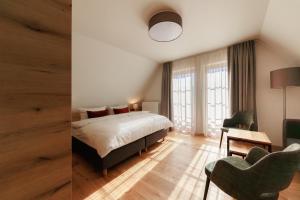 a bedroom with a bed and a desk and a chair at Hotel Amselgrundschlößchen in Kurort Rathen +37 photos