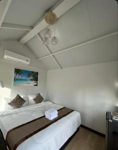 a bedroom with a large white bed with a ceiling at Lanta Junli House in Ko Kam Yai