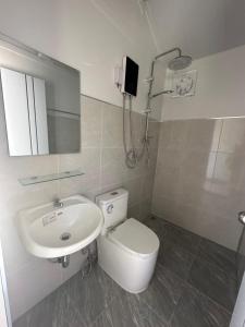 a bathroom with a sink and a toilet and a mirror at Lanta Junli House in Ko Kam Yai +16 photos