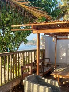 a patio with tables and chairs and a view of the ocean at Dizzy Lizzies Beach House Resort in Kokrobite