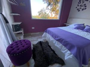a purple bedroom with a bed and a window at La Posada de Sofi in Concordia