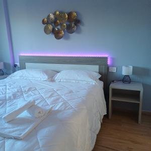 a bedroom with a white bed with a purple wall at Luxury Rooms Bari in Bari
