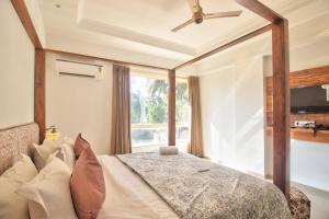ein Schlafzimmer mit einem Bett und einem großen Fenster in der Unterkunft Hotel Sea Sapphire in Calangute