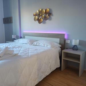 a bedroom with a white bed with a purple light at Luxury Rooms Bari in Bari