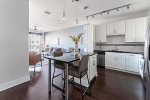 a kitchen and living room with a table and chairs at Landing Chic 1BD Gym Rooftop Lounge in Orlando