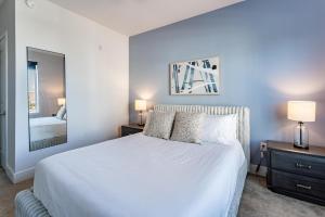 a bedroom with a white bed and a mirror at Landing Chic 1BD Gym Rooftop Lounge in Orlando +33 photos