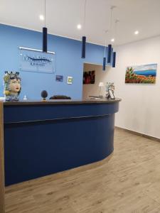 a bar in a room with a blue wall at Marea B&B in Milazzo