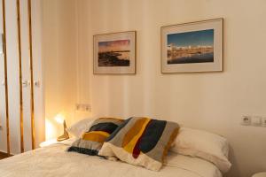 a bedroom with a bed and two pictures on the wall at Luz del Guadiana in Ayamonte