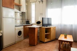 a kitchen with a refrigerator and a tv on a counter at Luz del Guadiana in Ayamonte