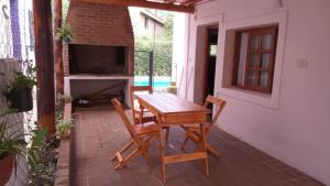 a wooden table and chairs on a patio at casitadearminda-II in Villa Las Rosas
