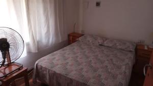 a bedroom with a bed and a fan and a window at casitadearminda-II in Villa Las Rosas