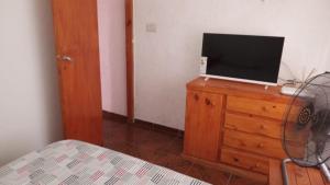 a bedroom with a bed and a television on a dresser at casitadearminda-II in Villa Las Rosas +1 photo