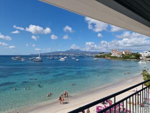 a view of a beach with people in the water at JCM location in Les Trois-Îlets