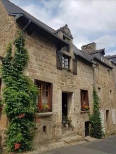 an old stone building with flowers in the window at Auberge de la Poterne in Moncontour