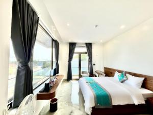 a bedroom with a large bed and a large window at The Moon Hotel in Quảng Trach