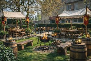 a fire pit in a yard with tables and benches at Auberge de la Poterne in Moncontour