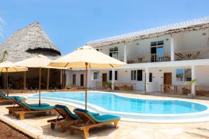 a resort with a swimming pool with chairs and umbrellas at OMNYA Nungwi Boutique Hotel in Nungwi