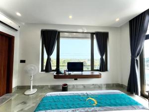 a bedroom with a bed with a window and a desk at The Moon Hotel in Quảng Trach +5 photos