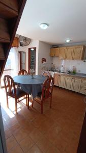 a kitchen with a table and chairs and a table and a kitchen at Excelente Departamento en Calle 44 - Deptos Apolo in Las Toninas