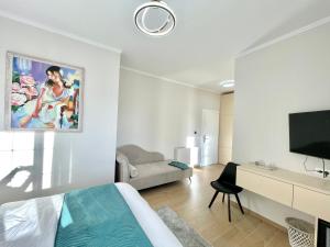 a bedroom with a bed and a tv and a couch at Villa Safira in Durrës
